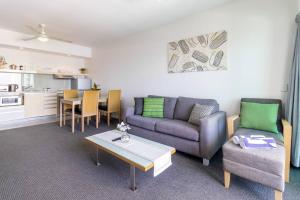 - un salon avec un canapé et une table dans l'établissement Habour & City View Apartment on 11th Floor - King Bed, à Darwin