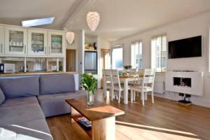uma sala de estar com um sofá azul e uma mesa em Salcombe Retreat Lodge 2 em Soar