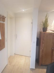 Zimmer mit weißer Tür und Holzboden in der Unterkunft Apartmenthaus Westerkoog in Hedwigenkoog