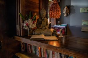 a desk with a buddha statue and books on it at Recanto de Sophie in Pipa