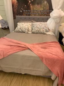 ein Bett mit einer orangefarbenen Decke und Kissen darauf in der Unterkunft Chalé Romântico Campina Grande do sul in Campina Grande do Sul