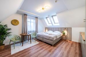 a bedroom with a bed and a table and chairs at Willa Lapwing in Sopot
