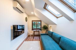 a living room with a blue couch and a table at Willa Lapwing in Sopot