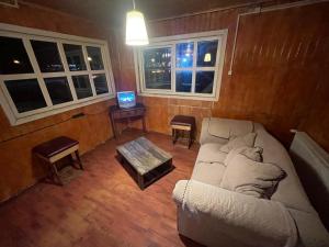 a living room with a white couch and a tv at Refugio 644 in Porvenir