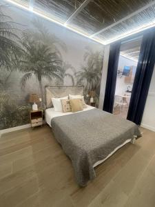 a bedroom with a large bed with palm trees on the wall at casa Albufera boutique in Valencia