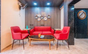 a waiting room with red chairs and a table at Treebo Trend City Center in Nagpur
