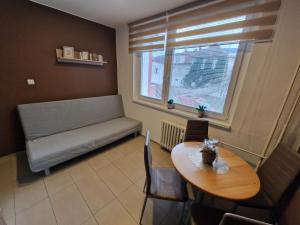 a room with a table and a bench and a window at Apartman Valentina in Zlín