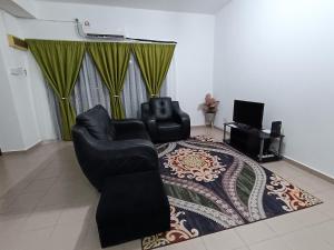 a living room with two chairs and a rug at Fausal Legacy Homestay Sungai Besar in Sungai Besar