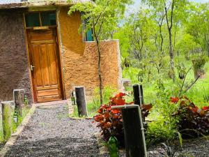 a house with a wooden door in a garden at Doublegsafaris and camp mikumi in Mikumi