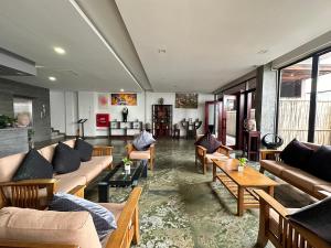 a living room with couches and tables and windows at WATBO BRIDGE Residence in Siem Reap