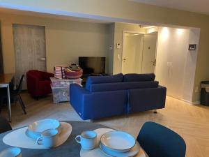 a living room with a blue couch and a table at Belair Studio in Tervuren