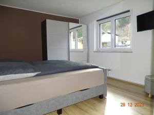 a bedroom with a bed and two windows at Glück auf - Ferienhaus zum Rauchfangkehrer in Wörgl