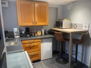 a small kitchen with a table and a microwave at STUDIO 3 Mn de la PLAGE Terrasse Vélos Proche de la ville fortifiée in Saint Malo