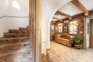Habitación grande con suelo de madera y escalera. en Villa Adria B&B, en Canazei
