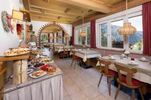 una sala da pranzo con tavolo e cibo di Small & Lovely Hotel Zaluna a Predazzo
