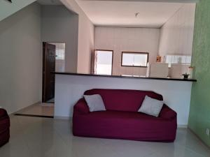 ein rotes Sofa im Wohnzimmer mit Küche in der Unterkunft Casa Familiar in Paraty