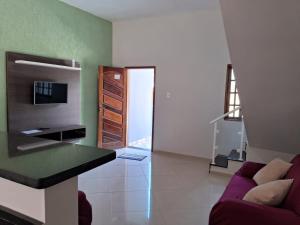 ein Wohnzimmer mit einem Sofa und einem TV in der Unterkunft Casa Familiar in Paraty
