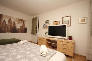 ein Schlafzimmer mit einem TV auf einer Holzkommode in der Unterkunft Kaya Apartments in Sarajevo