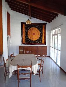 ein Esszimmer mit einem Tisch und Stühlen sowie einem Gemälde an der Wand in der Unterkunft POSADA DE LA LUNA in Ciudad Lujan de Cuyo