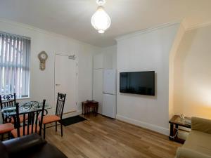 een woonkamer met een bank en een tv aan de muur bij Pass the Keys Cosy Flat in Newcastle Upon Tyne in Elswick