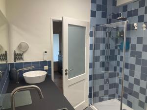 a bathroom with blue tiles and a glass shower at African Tree in Terwolde