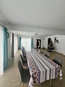 a room with a table with chairs and a christmas tree at Casa Vera in Vidra