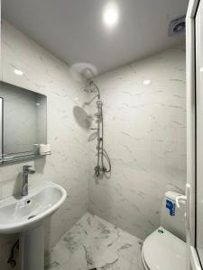 biała łazienka z umywalką i toaletą w obiekcie Woodland Borjomi w Bordżomi