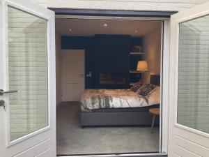 a bedroom with a bed through a sliding glass door at African Tree in Terwolde