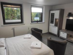 Zimmer mit einem Tisch, Stühlen und einem TV in der Unterkunft Ferienwohnung Neubrandenburg-Broda - Ruhe und mehr in Neubrandenburg