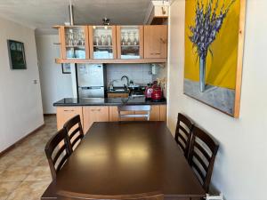 cocina con mesa y sillas en una habitación en Departamento en el corazón de Reñaca en Viña del Mar