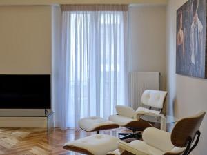 sala de estar con sillas blancas y TV en Quiet, central 2bd Apt, Kolonaki, en Atenas