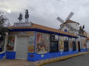 a building with paintings on it with a windmill at Rincones de Darío: Capítulo II in Puerto Lápice