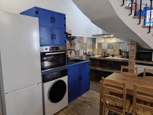 a kitchen with blue cabinets and a sink and a table at Rincones de Darío: Capítulo II in Puerto Lápice