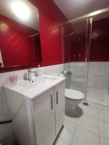 a bathroom with a white sink and a toilet at Home Granada Trinidad in Granada