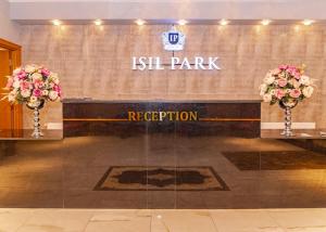 a sign for the ishtar park with two vases with flowers at IŞIL PARK HOTEL in Kars