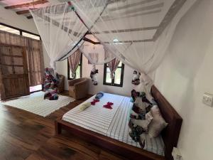 a bedroom with two beds with mosquito nets at Dreamland Bungalows Michamvi Kae in Michamvi