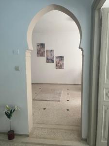 an archway leading into a white room with paintings at Ideal location in the heart of L’hivernage in Marrakesh