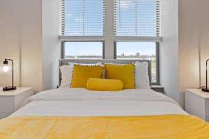 a bedroom with a bed with yellow pillows and a window at Affordable 2-Bedroom DT Detroit. in Detroit