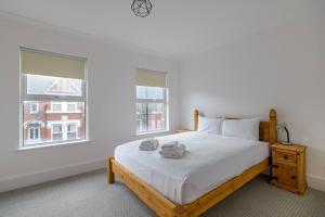 a bedroom with a bed with two towels on it at Pass the Keys - Spacious House with a Garden in Stratford, London in London