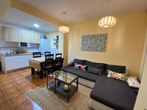 a living room with a couch and a table and a kitchen at TU ESPACIO:Confort y Diversión. in San Martín de Valdeiglesias