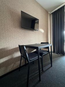 a room with a table and a chair and a television at Zajazd Irina in Białystok