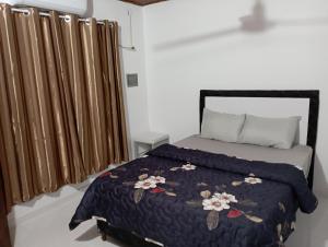 - une chambre avec un lit et une couette noire dans l'établissement Casa amoblada en Villarrica - Py, à Villarrica