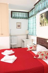 a bedroom with a red bed with a red blanket at Verdon in Rome