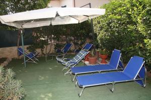 un groupe de chaises bleues sous un parapluie dans l'établissement Verdon, à Rome