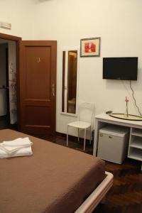 - une chambre avec un lit, un bureau et une télévision dans l'établissement Verdon, à Rome