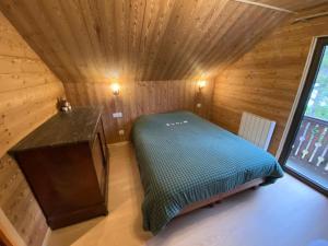 a room with a bed in a wooden cabin at Chalet proche Valberg in Guillaumes