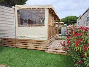 a wooden deck with a gazebo in a yard at Muriel Le Mar Estang in Canet-en-Roussillon