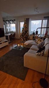 a living room with a christmas tree and a couch at Adorable Arctic Apartment with sauna in Rovaniemi