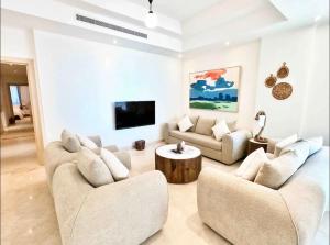 a living room with two couches and a tv at Chic/Elegant 4 Bedrooms… in Jeddah