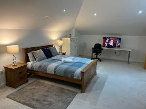 - une chambre avec un lit et une télévision dans l'établissement Ensuite Room w/ private entrance in Royal Victoria Excel O2 Arena London, à Londres
